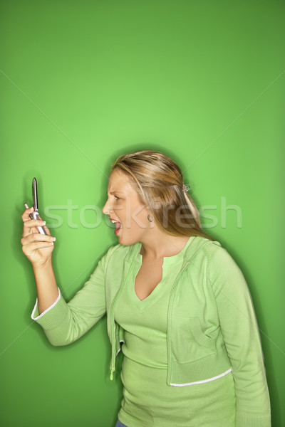 Girl looking shocked at cellphone. Stock photo © iofoto