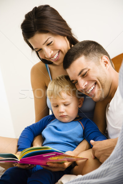 Familie lectură carte caucazian părinţi copil Imagine de stoc © iofoto