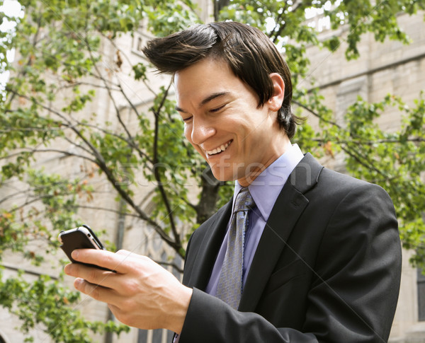 Zakenman glimlachend mobiele telefoon bericht asian zakenman Stockfoto © iofoto