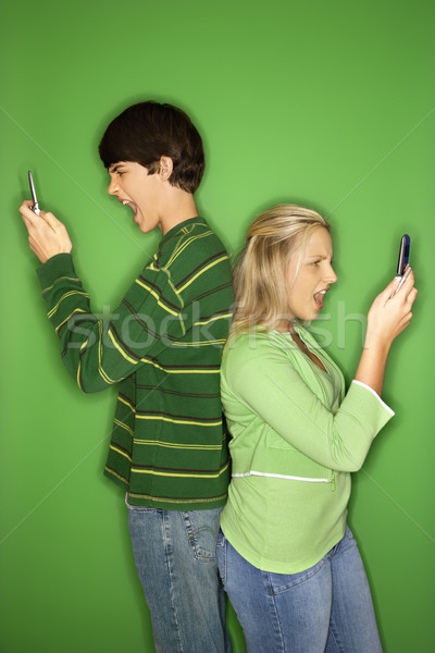 Boy and girl on cellphones. Stock photo © iofoto