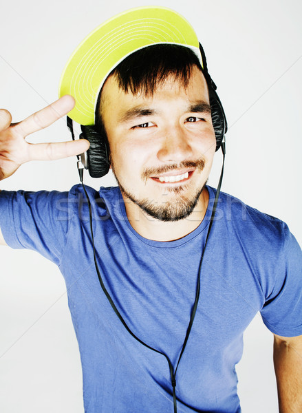 young asian man in hat and headphones listening music on white b Stock photo © iordani