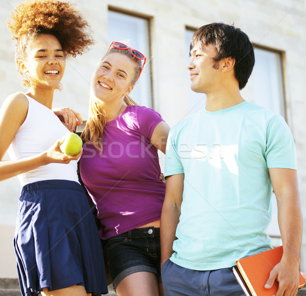 cute group of teenages at the building of university with books huggings, back to school Stock photo © iordani