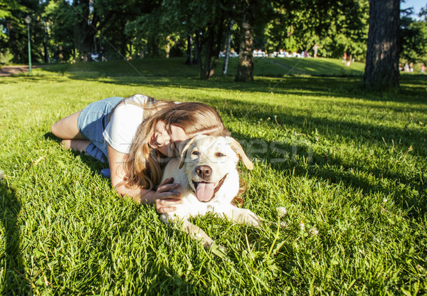 young attractive blond woman playing with her dog in green park at summer, lifestyle people concept Stock photo © iordani