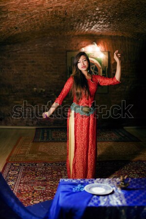 young pretty asian girl in bright colored interior on carpet Stock photo © iordani
