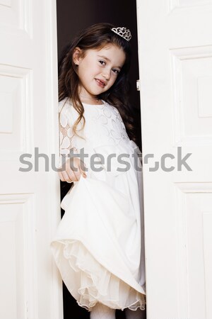 Stock photo: little cute girl at home, opening door well-dressed in white dre