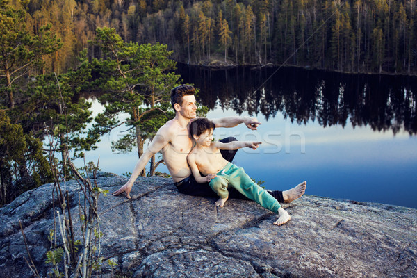 middle age man with little cute son doing sport yoga on the top of the mountain together, happy fami Stock photo © iordani