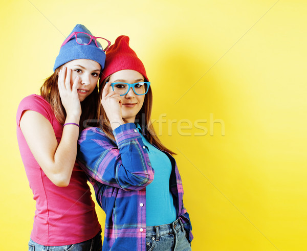 lifestyle people concept: two pretty young school teenage girls having fun happy smiling on yellow b Stock photo © iordani