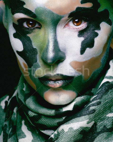 Beautiful young fashion woman with military style clothing and face paint make-up, khaki colors Stock photo © iordani