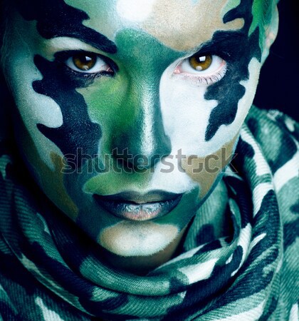 Beautiful young fashion woman with military style clothing and face paint make-up, khaki colored Stock photo © iordani