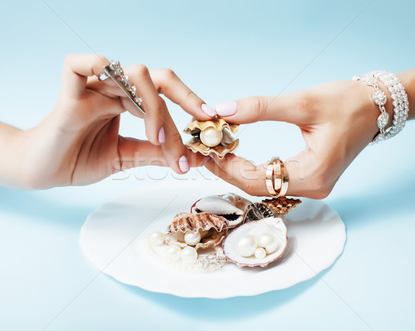 beautiful woman hands with pink manicure holding plate with pearls and sea shells, luxury jewelry co Stock photo © iordani