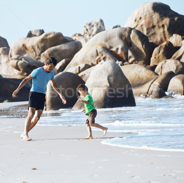 happy family on beach playing, father with son walking sea coast Stock photo © iordani