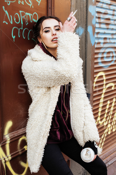 young pretty stylish teenage girl outside in city wall with graf Stock photo © iordani