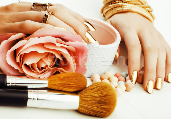 Stock photo: woman hands with golden manicure and many rings holding brushes,