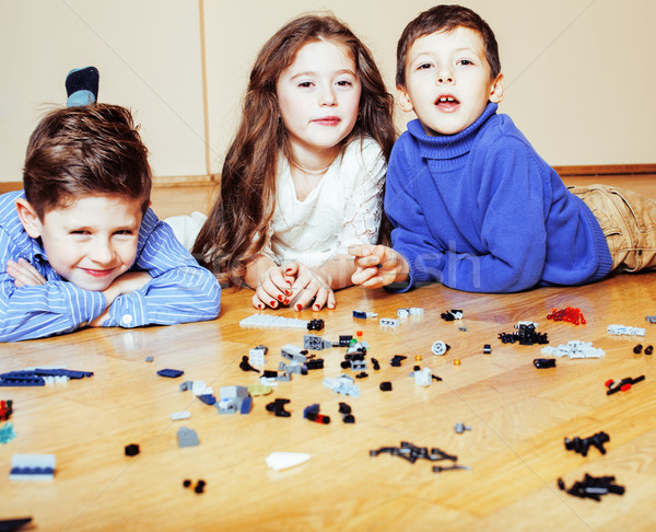 funny cute children playing lego at home, boys and girl smiling, first education role lifestyle Stock photo © iordani