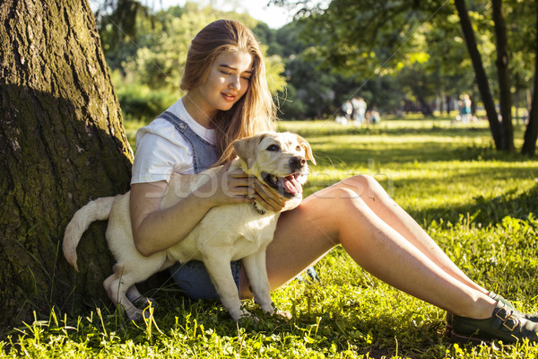 young attractive blond woman playing with her dog in green park at summer, lifestyle people concept Stock photo © iordani