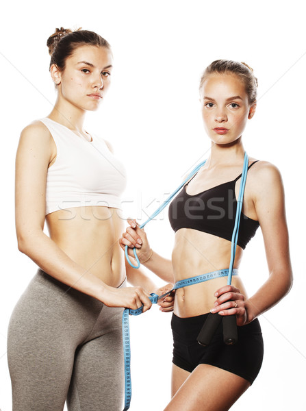 two sport girls measuring themselves isolated on white Stock photo © iordani