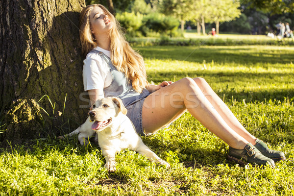 young attractive blond woman playing with her dog in green park at summer, lifestyle people concept Stock photo © iordani