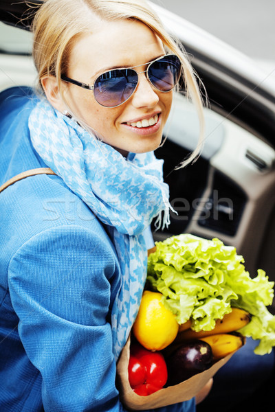 young pretty blond woman with food in bag walking on street Stock photo © iordani