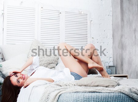 young pretty brunette girl laying in cozy bed with coffee wearing wool winter sweater happy smiling, Stock photo © iordani