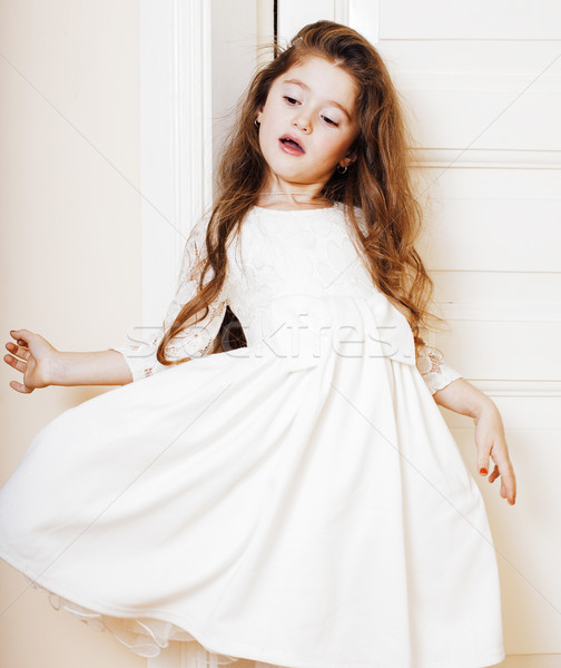 little cute girl at home, opening door well-dressed in white dre Stock photo © iordani