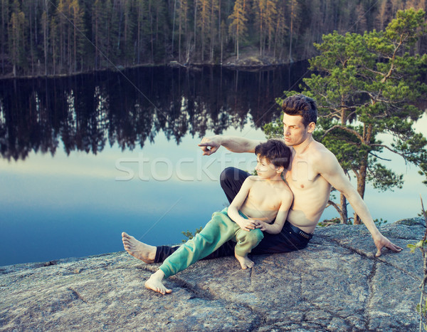 middle age man with little cute son doing sport yoga on the top of the mountain together, happy fami Stock photo © iordani