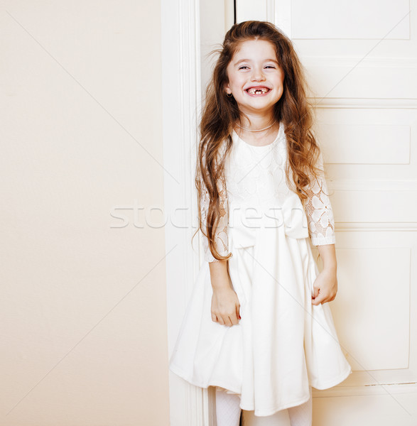 Stock photo: little cute girl at home, opening door well-dressed in white dre