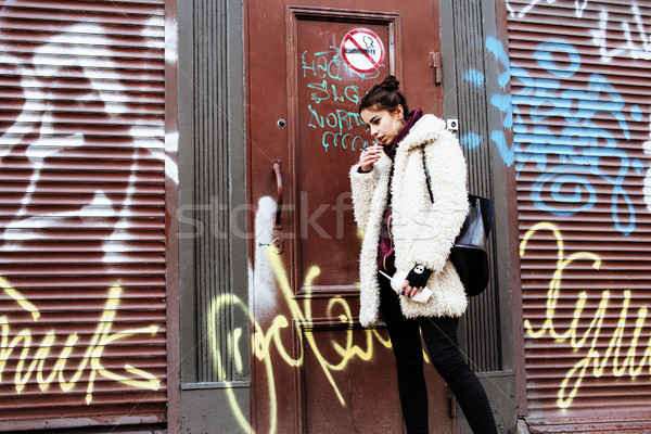 young pretty stylish teenage girl outside in city wall with graf Stock photo © iordani