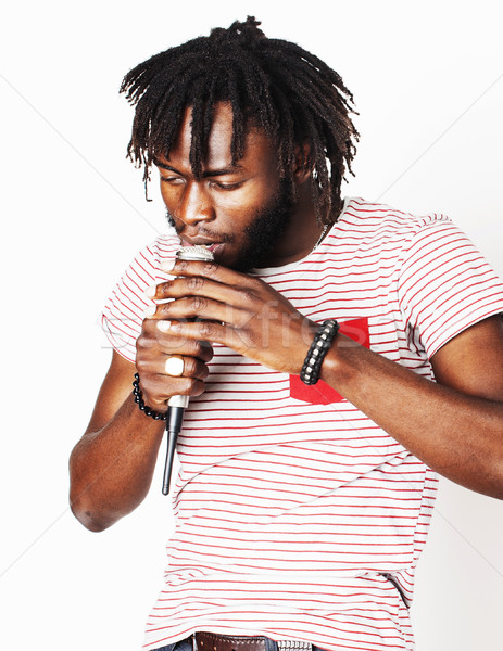young handsome african american boy singing emotional with microphone isolated on white background,  Stock photo © iordani