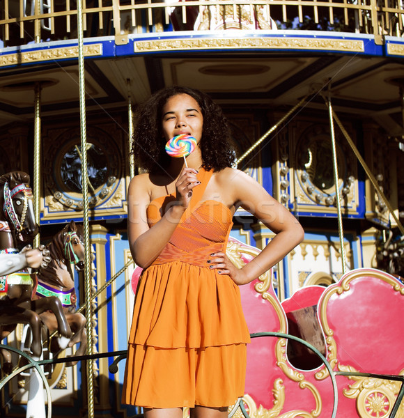 cool real teenage girl with candy near carousels at amusement pa Stock photo © iordani