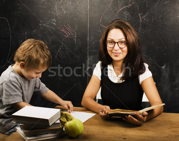 little cute boy with young teacher in classroom studying at blac Stock photo © iordani