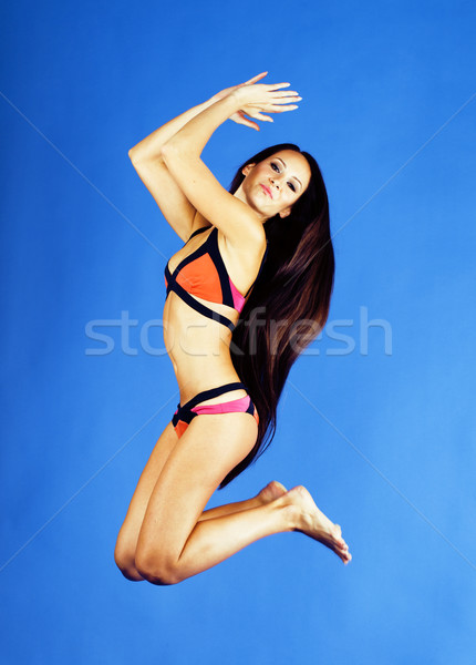 young pretty smiling happy slim jumping girl in bikini on blue background, lifestyle people on vacat Stock photo © iordani