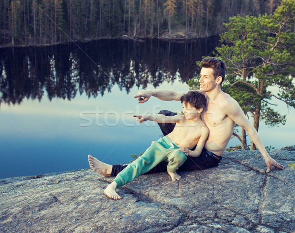 middle age man with little cute son doing sport yoga on the top of the mountain together, happy fami Stock photo © iordani