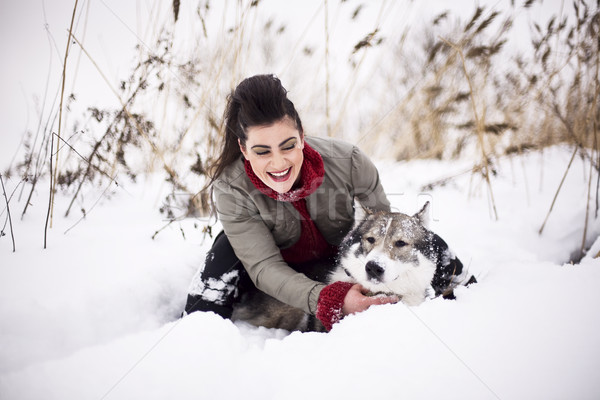 Young fashion girl walking playing with husky dog outside in winter snow park, having fun together,  Stock photo © iordani