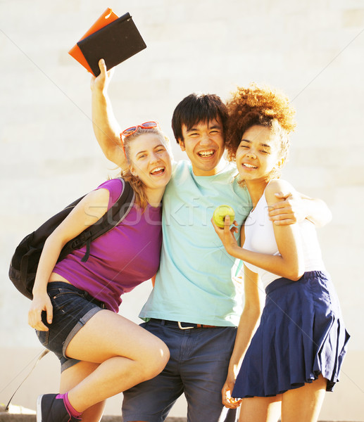cute group of teenages at the building of university with books huggings Stock photo © iordani