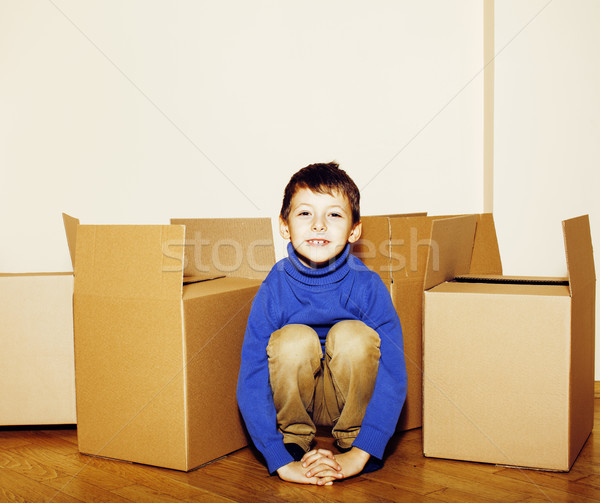 little cute boy in empty room, move to new house. home alone among boxes close up kid smiling, lifes Stock photo © iordani