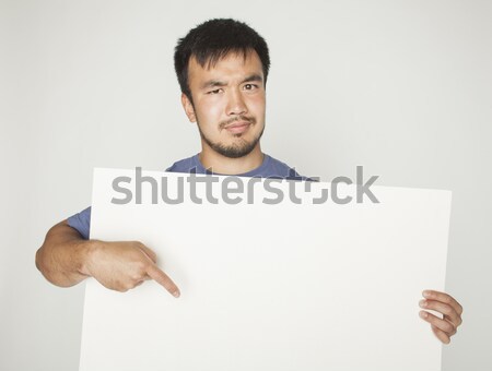 Stock photo: pretty cool asian man holding empty white plate smiling