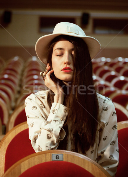 portrait of a pretty girl hipster in a movie theater wearing hat, dreaming alone Stock photo © iordani