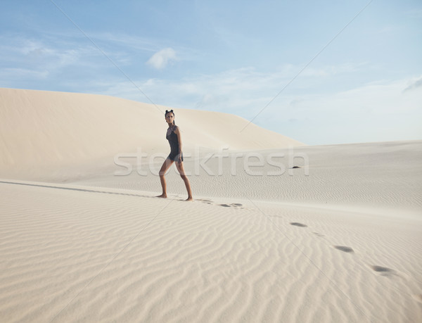 young pretty woman in white sand dunes like a goddes of darkness Stock photo © iordani