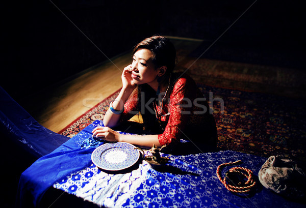 young pretty asian girl in bright colored interior on carpet view, oriental people lifestyle concept Stock photo © iordani