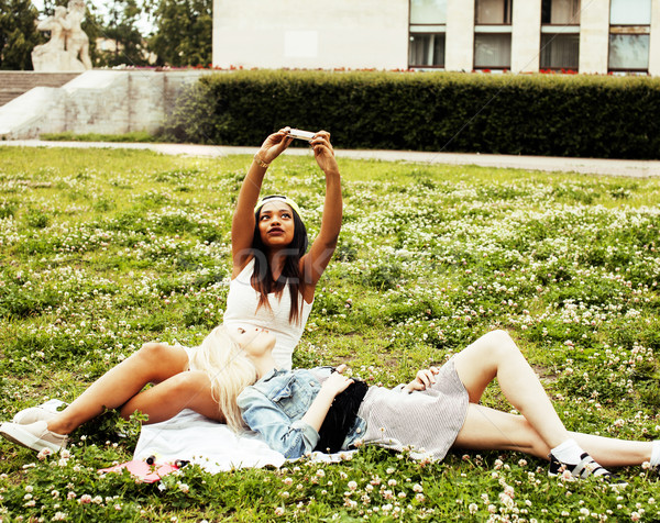 two young pretty teenager girls best friends laying on grass making selfie photo having fun, lifesty Stock photo © iordani