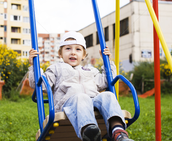 little cute boy playing on playground, hanging on gymnastic ring Stock photo © iordani
