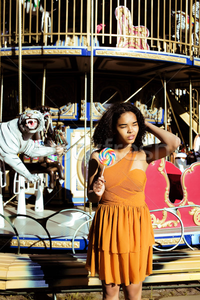 cool real teenage girl with candy near carousels at amusement pa Stock photo © iordani