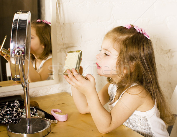 little cute girl with lipstick at mirror, trying do makeup like  Stock photo © iordani