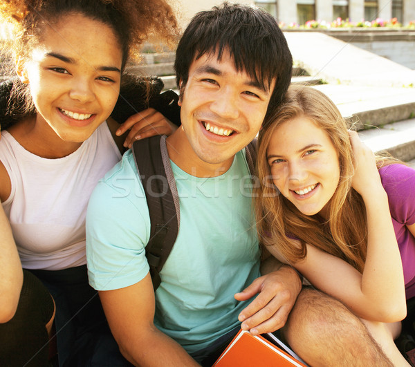 cute group of teenages at the building of university with books huggings, back to school Stock photo © iordani