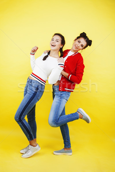 lifestyle people concept: two pretty school girl having fun on yellow background, happy smiling stud Stock photo © iordani