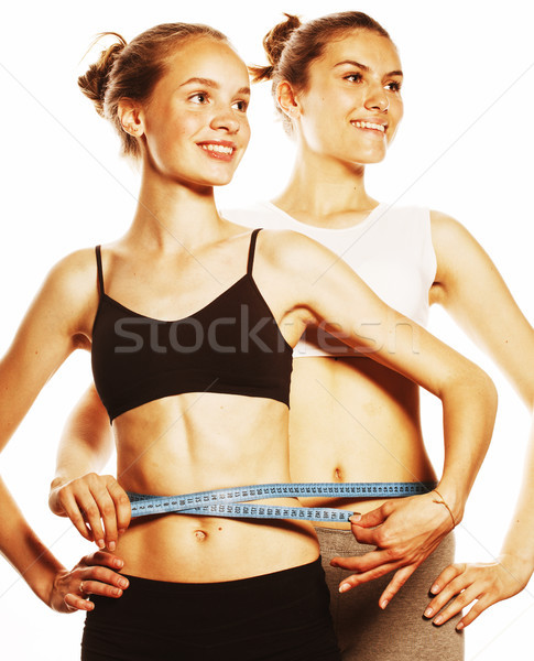 two sport girls measuring themselves isolated on white Stock photo © iordani