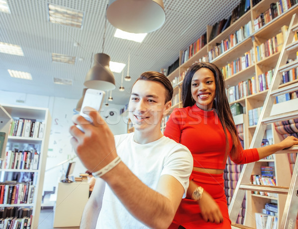 couple students in univercity library, looking book, preparing to exam, having fun, making selfie, l Stock photo © iordani