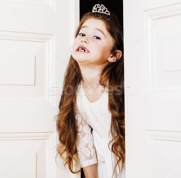little cute girl at home, opening door well-dressed in white dre Stock photo © iordani