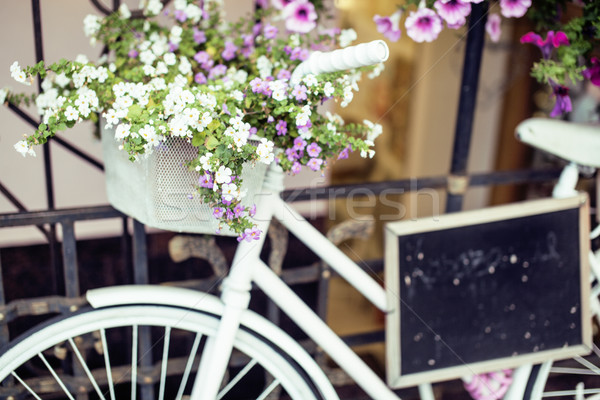 Stock photo: flower in basket of vintage bicycle on vintage wooden house wall, summer street cafe