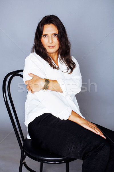 Destul de bruneta femeie matura şedinţei scaun studio Imagine de stoc © iordani